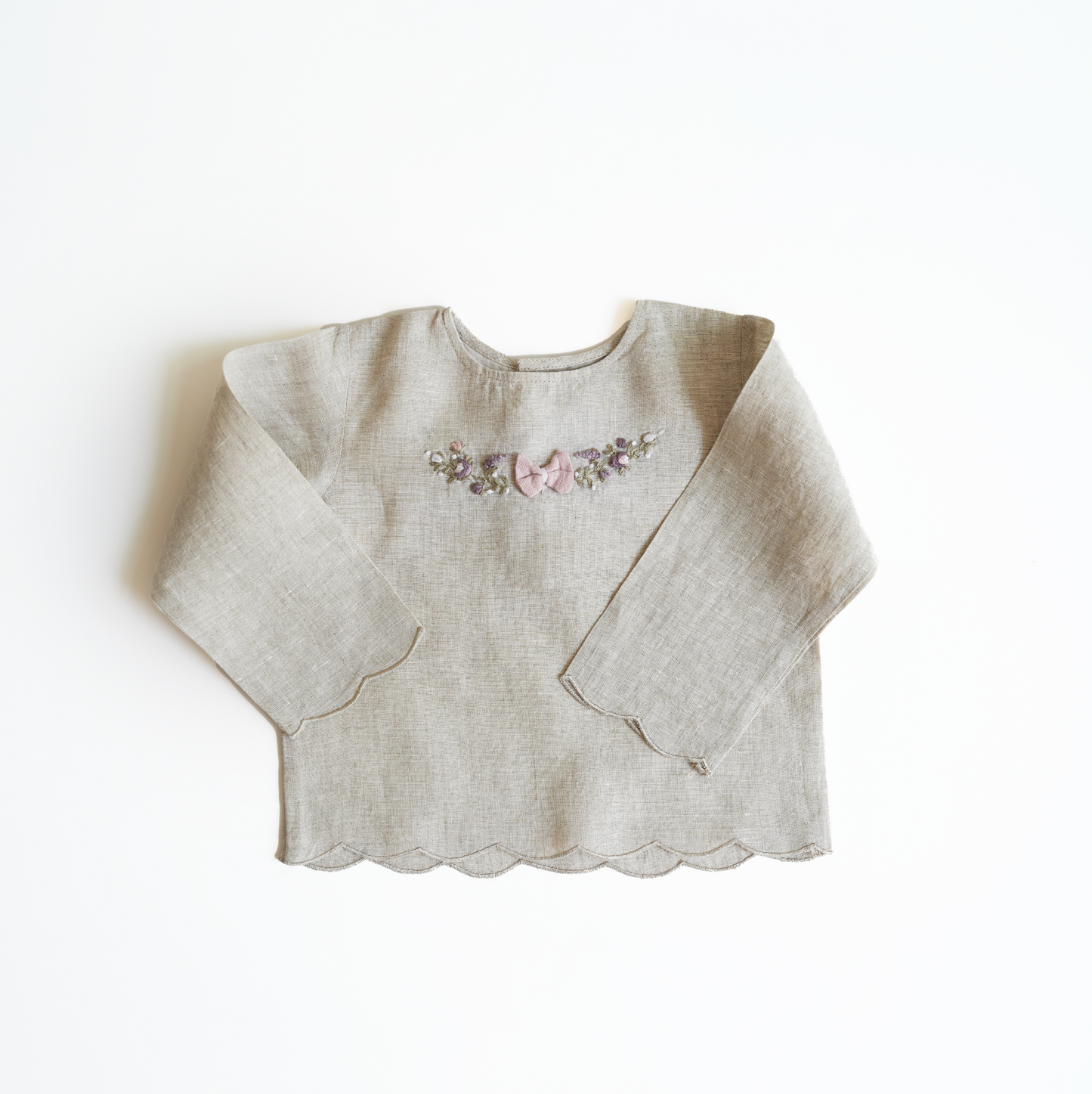 Pink hand embroidered polka dot shorts and top set in pure linen fabric, featuring floral embroidery and matching bow for children’s wear.