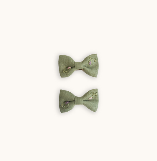 Pastel green linen hand-embroidered bow, designed to perfectly match with baby girls' tops. Adds a touch of luxury and elegance to any outfit, ideal for high-end baby accessories and stylish children's collections.