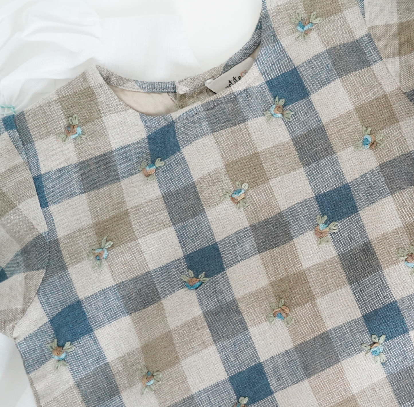 Chequered hand-embroidered top in pure linen with comfortable cotton lining and scalloped hem, perfect for stylish and cozy baby wear. Ideal for baby girls' designer wear and comfortable luxury clothing collections.