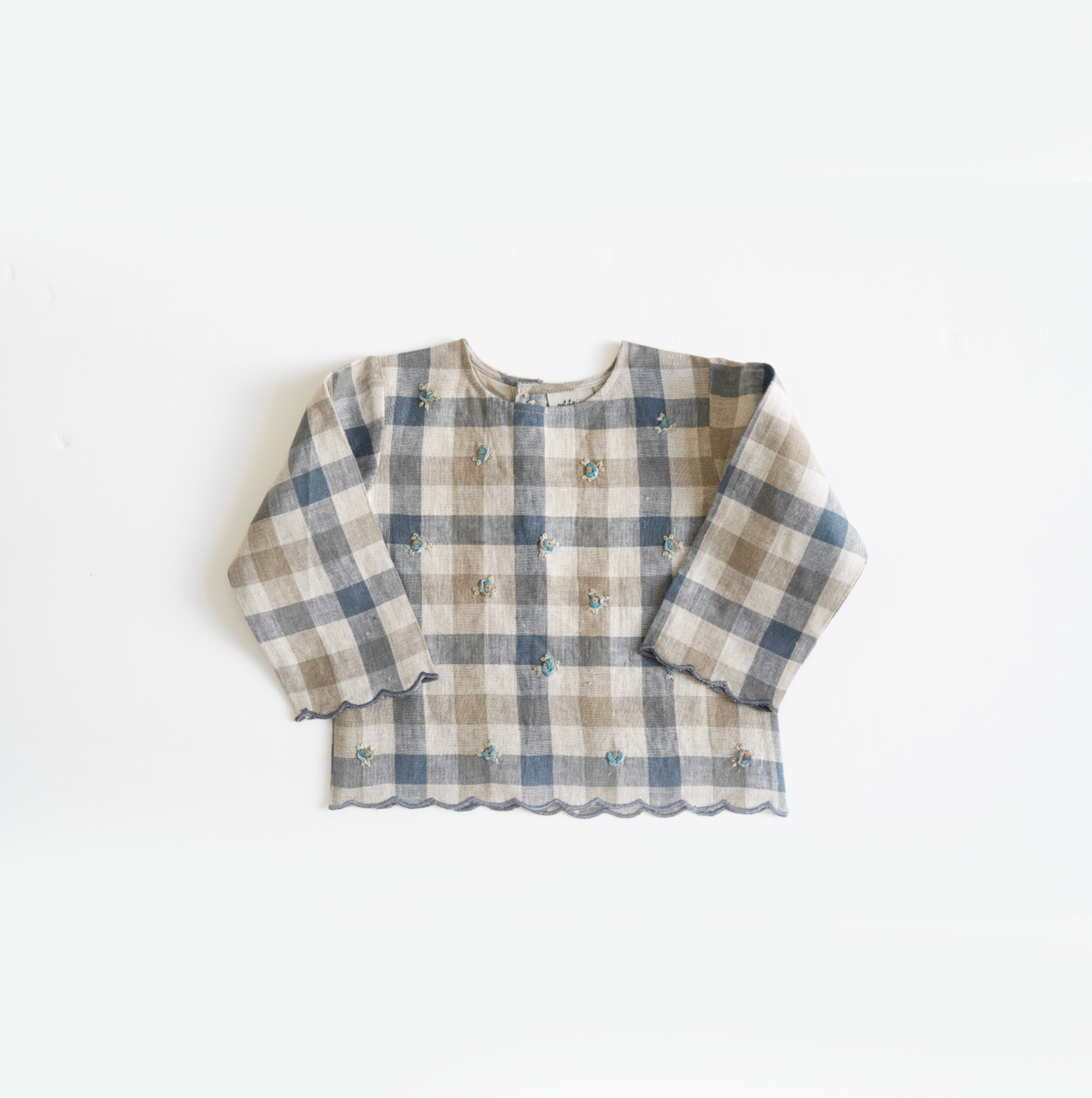 Chequered hand-embroidered top in pure linen with comfortable cotton lining and scalloped hem, perfect for stylish and cozy baby wear. Ideal for baby girls' designer wear and comfortable luxury clothing collections.